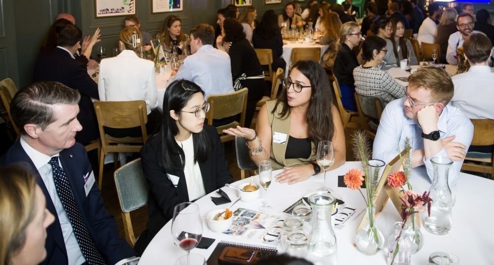 Alicia in conversation with colleagues at an event
